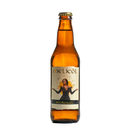 La imagen muestra una botella ámbar de hidromiel Melicol. Cada botella tiene una etiqueta papel champaña con la imagen de una mujer con los brazos abiertos sobre una explosión dorada y la palabra "Melicol" en la parte superior, seguido de "HIDROMIEL" en la parte inferior. Las tapas de las botellas son de color dorado oscuro. El fondo es blanco, resaltando la botella y etiqueta.